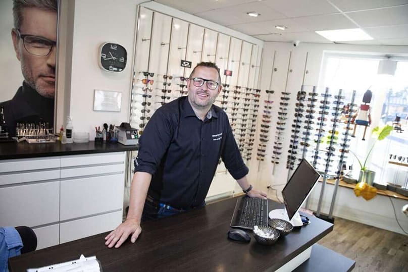 Optician employee standing at the reception desk