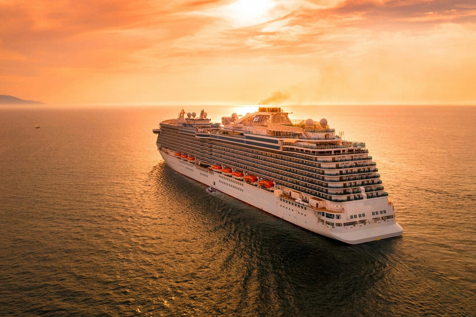 picture of a cruise ship sailing out to sea under a sunset sky