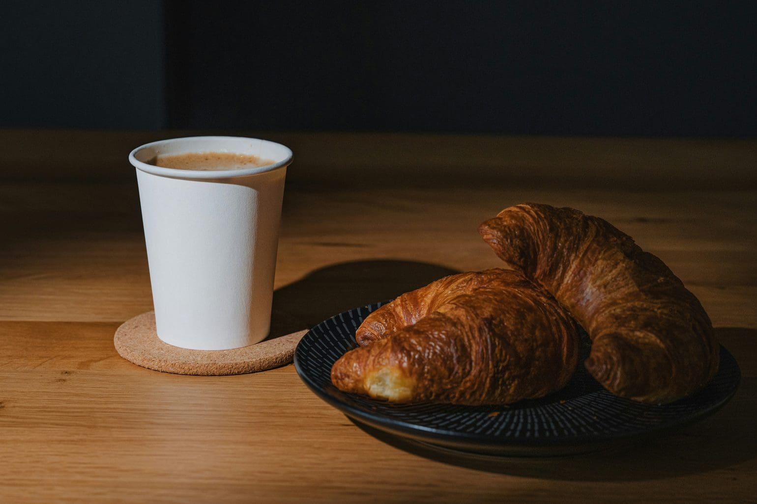picture of two croissants and a cup of coffee