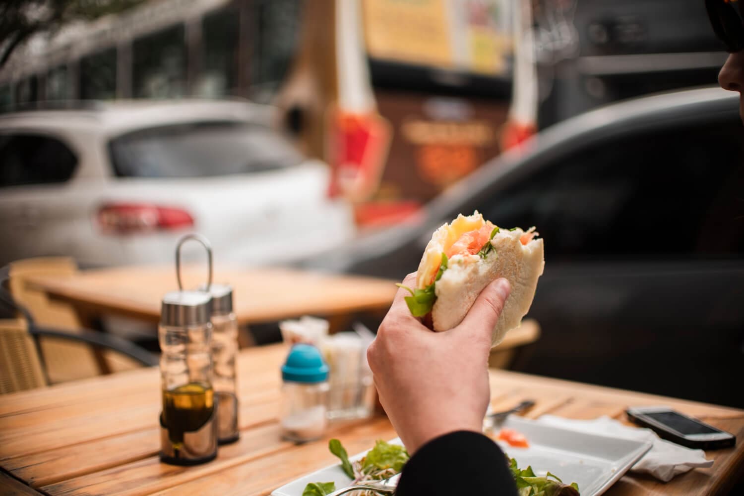 person sitting and eating a lunch burger outside