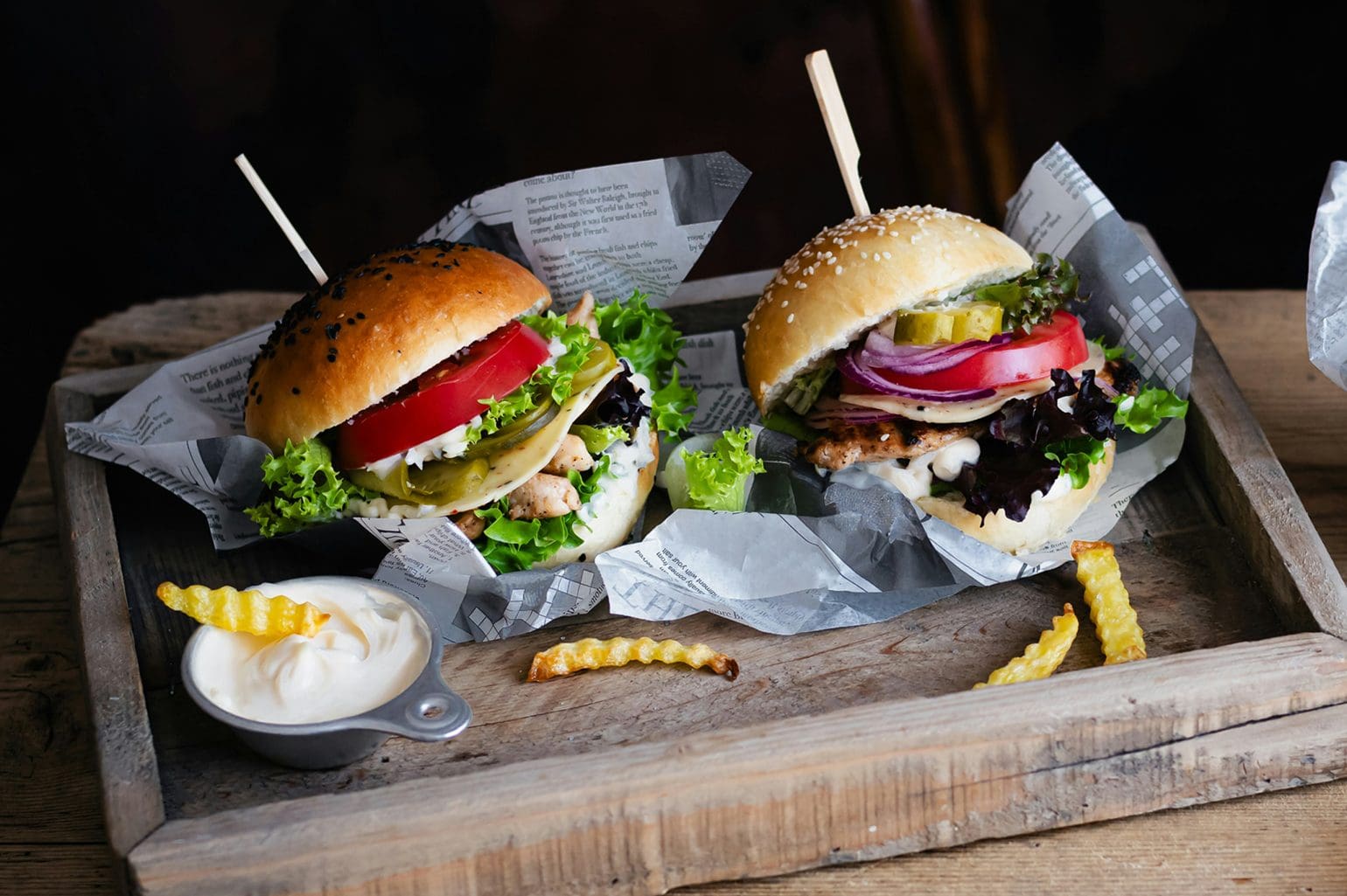 picture of two burgers on a wooden platter