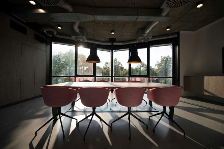 picture of a meeting room with 8 chairs and a table with a view of green trees